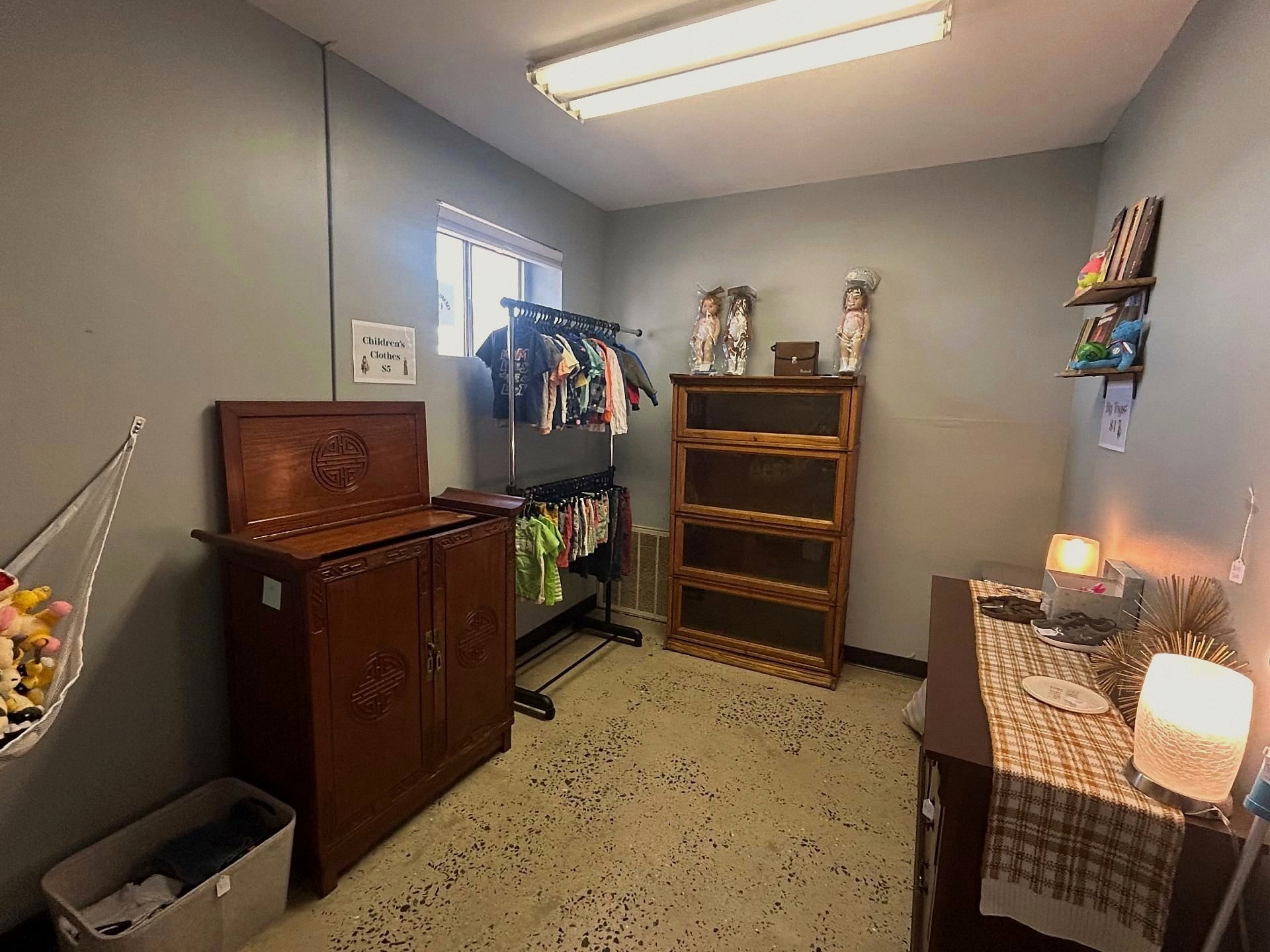 Children's clothes rack, vintage cabinet, and lamps in a cozy corner of the store