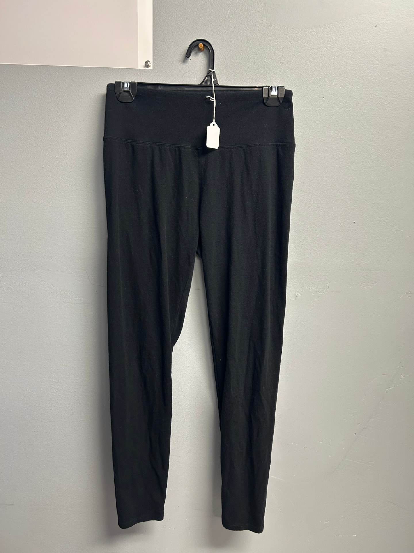 Solid black ankle-length leggings on a hanger