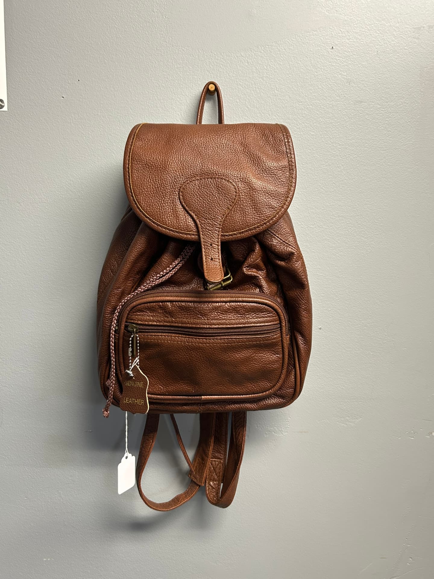 Brown pebbled genuine leather backpack with hanging leather tag