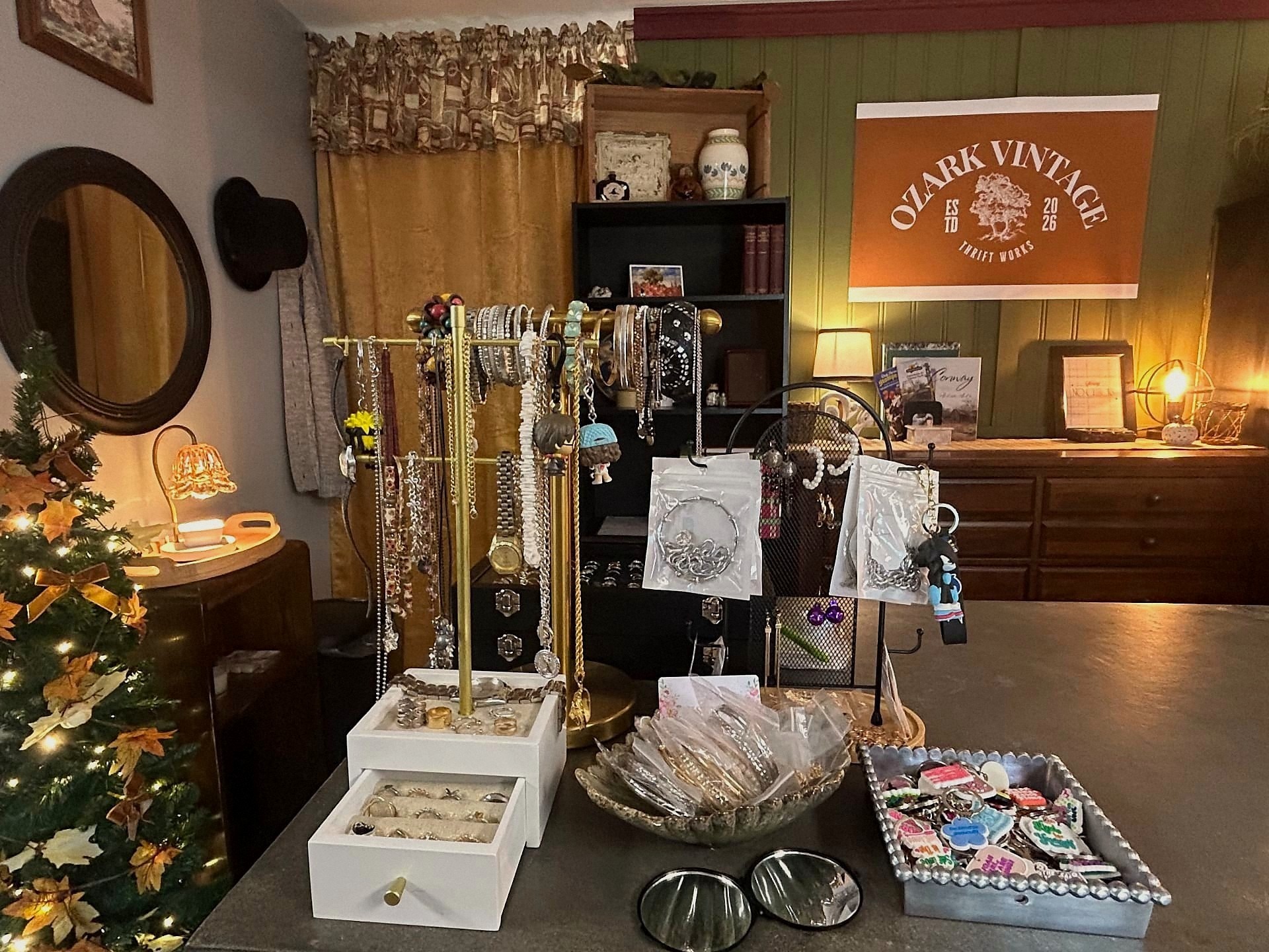 Jewelry counter with vintage necklaces, rings, and bracelets under the store banner