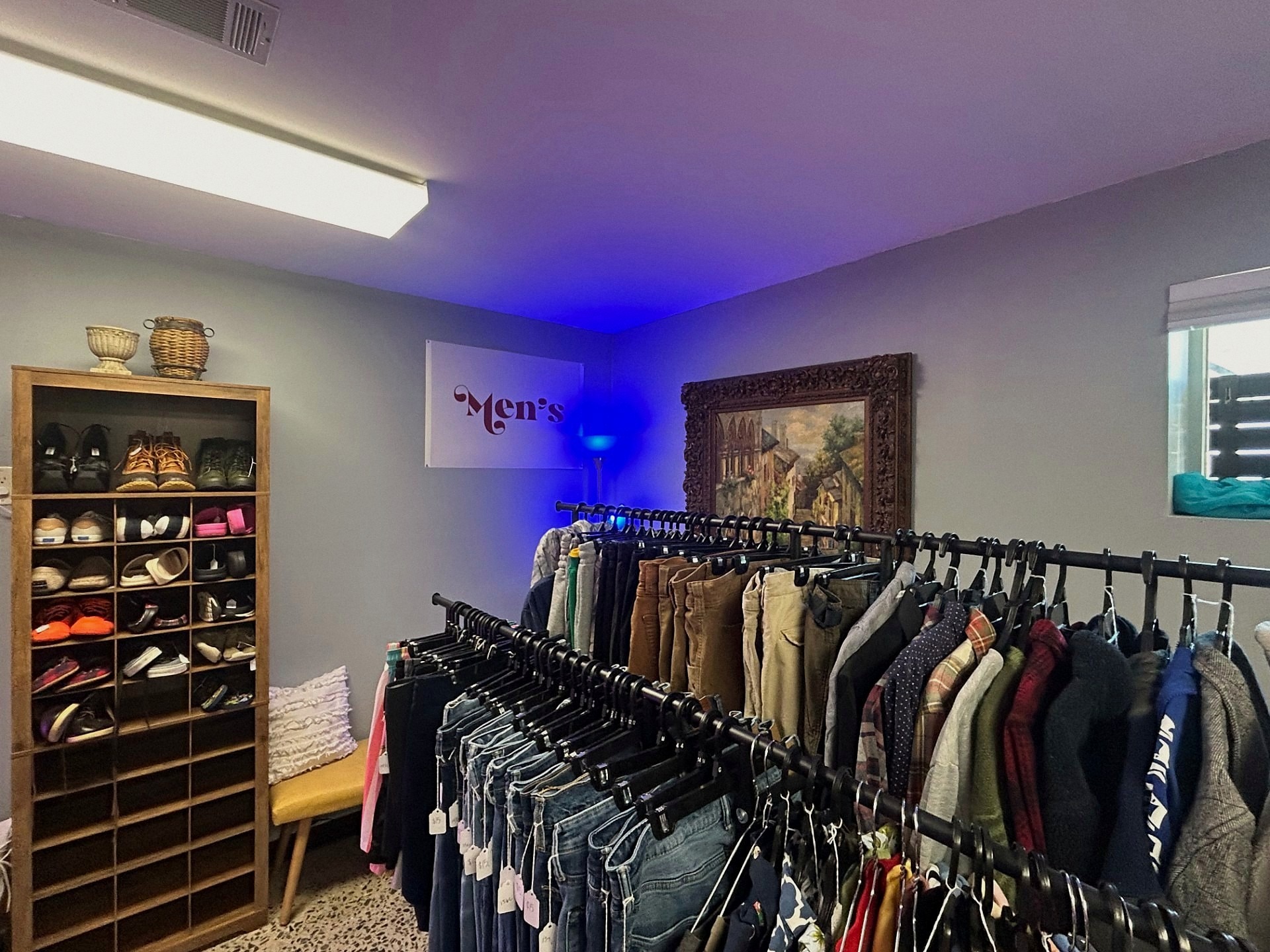 Men's section with the shoe cabinet, artwork, and racks of vintage jeans and chinos