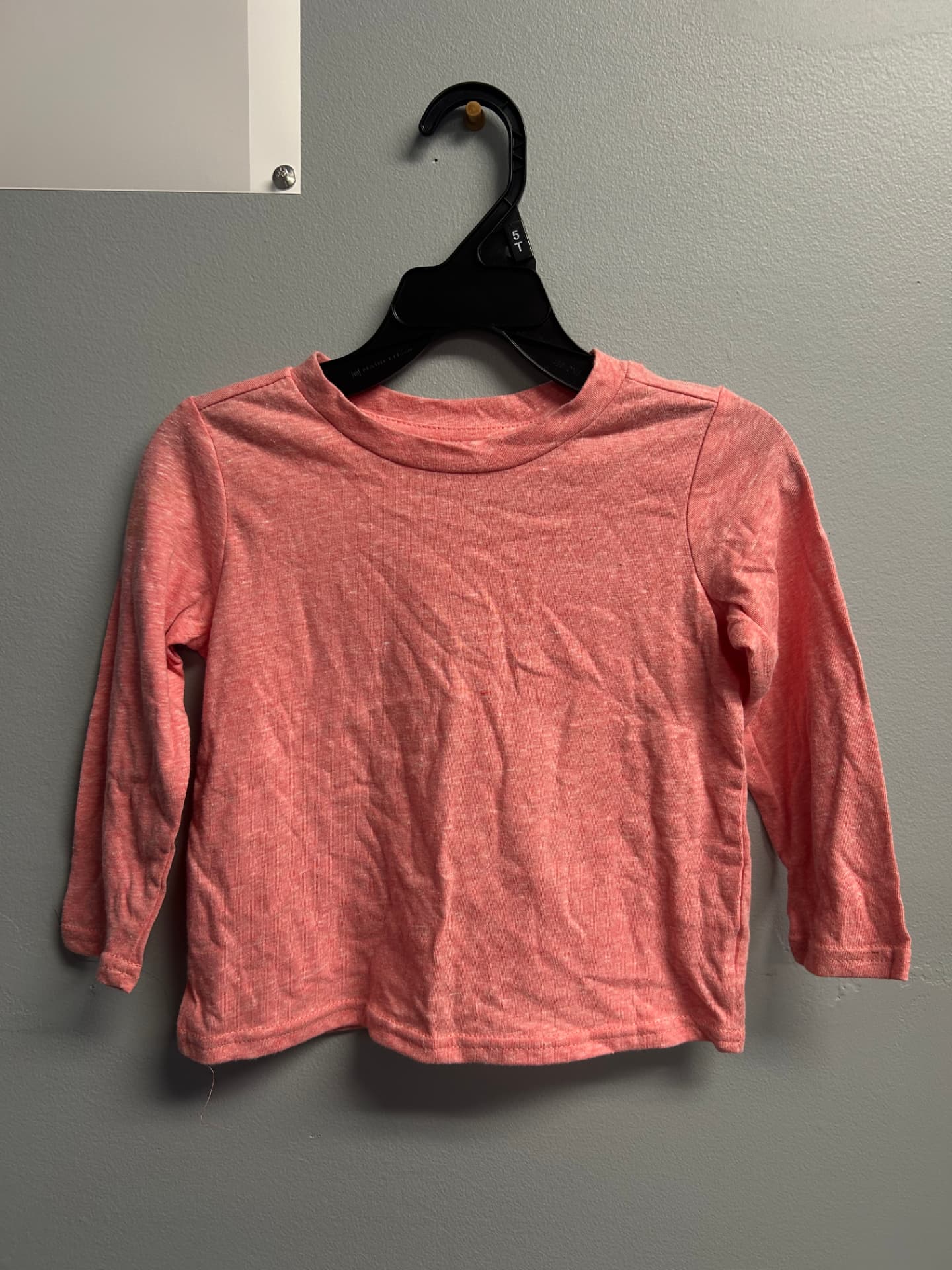 Heathered coral pink long-sleeve crew-neck toddler shirt on a hanger