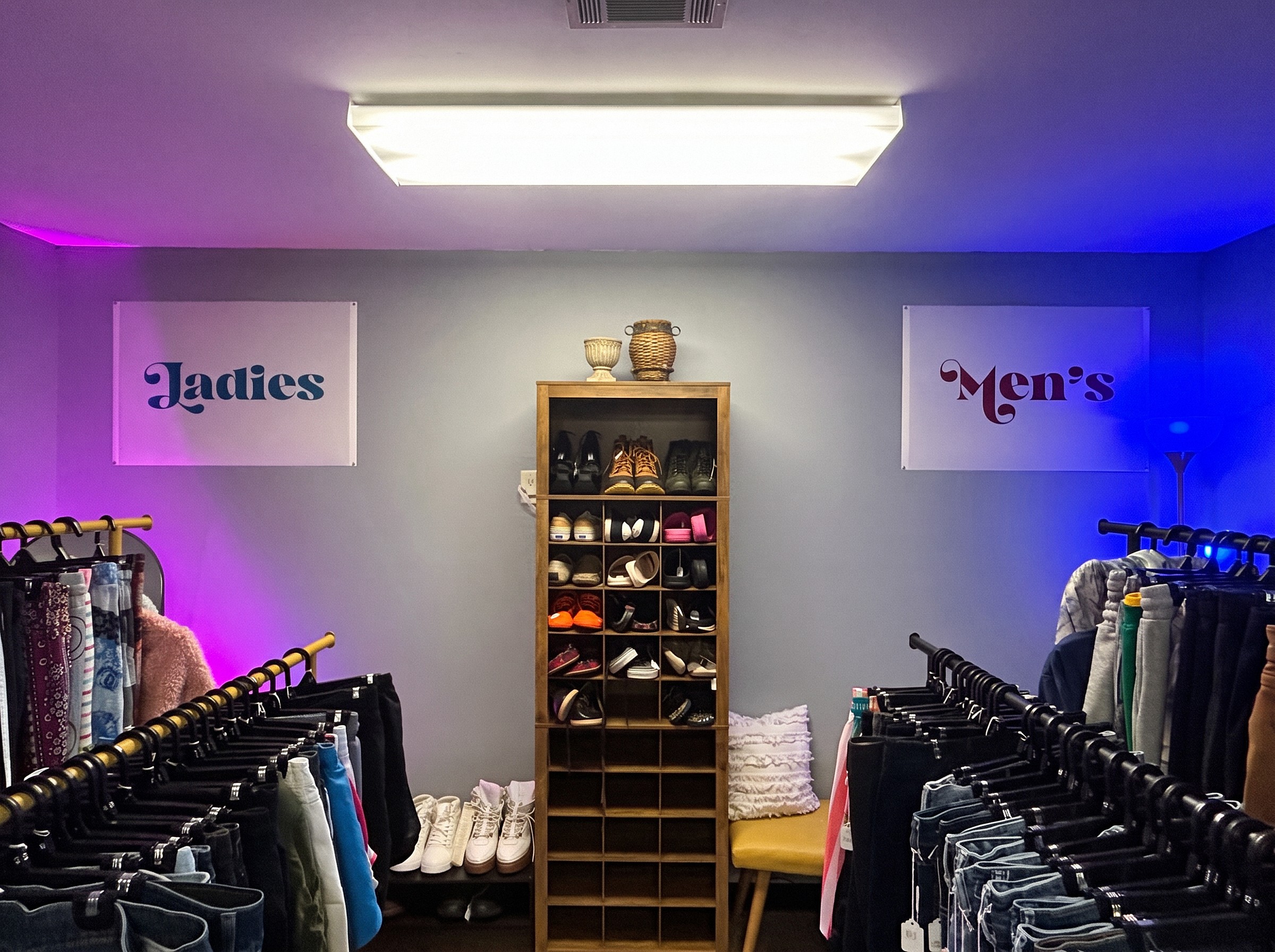 Ladies and Men's clothing racks with a shoe cabinet between them at Ozark Vintage Thrift Works