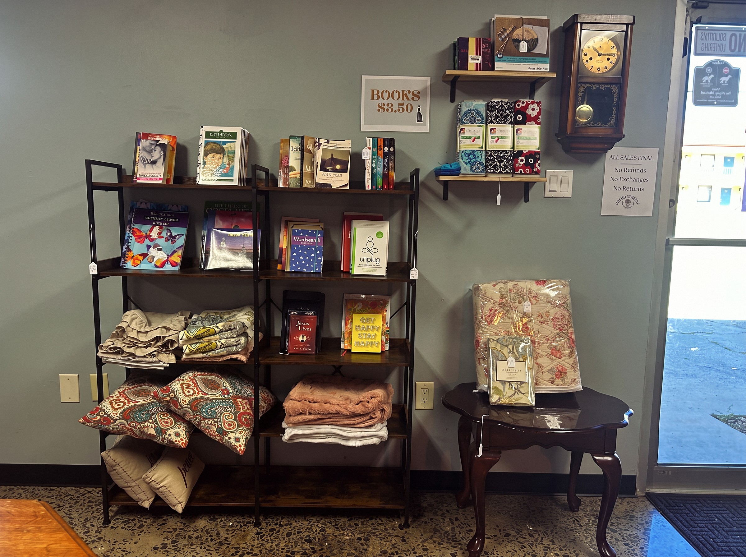 Books, linens, pillows, and vintage homewares displayed inside Ozark Vintage Thrift Works